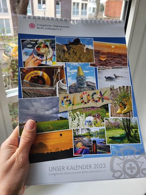 Ein Bilderkalender wird in die Kamera gehalten